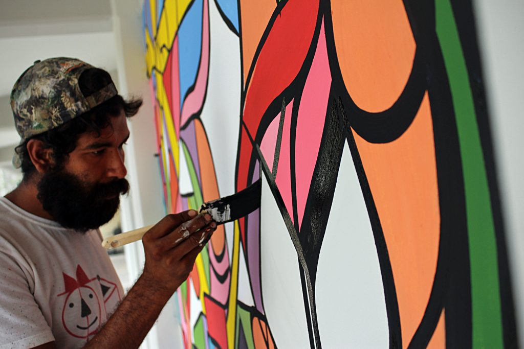 Miguel Asa pintando mural