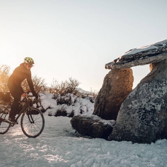 Ciclista y dolmen en la nieve